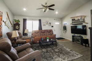 Living area with ceiling fan, baseboards, lofted ceiling, dark wood-style flooring, and recessed lighting