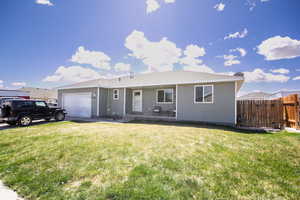 Ranch-style home with fence, an attached garage, and a front yard