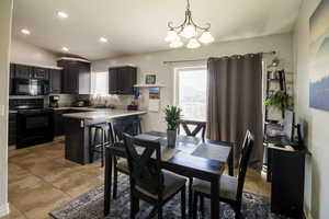 Dining room featuring light tile patterned flooring, recessed lighting, and an inviting chandelier