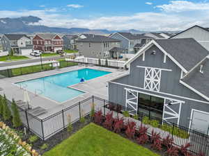 Pool with a lawn, fence, a residential view, and a barn