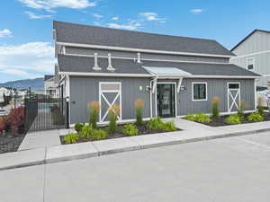 View of front of home with a gate, fence, board and batten siding, roof with shingles, and a mountain view