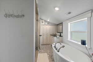 Full bath with a shower stall, lofted ceiling, visible vents, vanity, and a bath