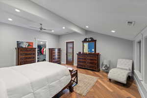 Bedroom featuring a ceiling fan, a spacious closet, lofted ceiling with beams, light wood-type flooring, and baseboards