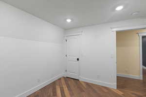 Unfurnished room with baseboards, dark wood-style flooring, and recessed lighting