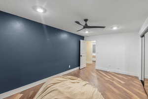 Unfurnished bedroom featuring baseboards, a ceiling fan, wood finished floors, and a closet