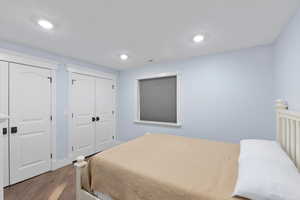 Bedroom featuring visible vents, multiple closets, wood finished floors, and recessed lighting