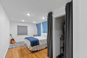 Bedroom with light wood-style flooring, baseboards, and recessed lighting