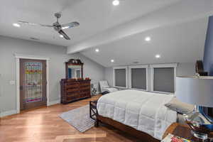 Bedroom with light wood-style flooring, vaulted ceiling with beams, baseboards, visible vents, and recessed lighting