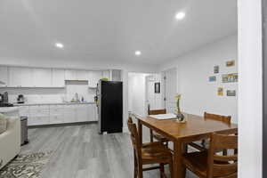 Dining space with recessed lighting and light wood finished floors