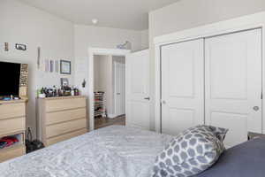 Bedroom with wood finished floors and a closet