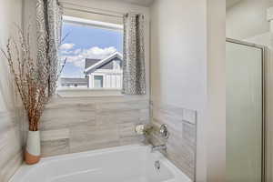 Full bath featuring a bath and a shower with shower door