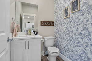 Full bathroom featuring wood finished floors, toilet, and vanity