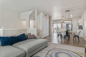 Living area with light wood finished floors, baseboards, and visible vents