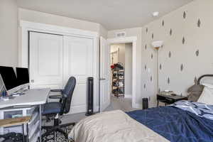 Carpeted bedroom with baseboards, visible vents, and a closet
