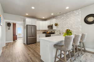 Kitchen featuring an island/bar, light quartz countertops, and stainless steel appliances