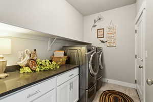Laundry area featuring baseboards, washer and clothes dryer, and folding area