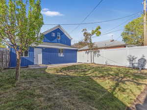 Rear view of house with a lawn and a fenced backyard
