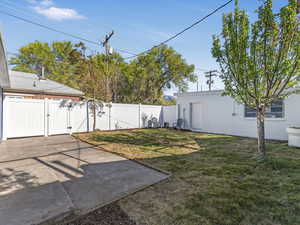 View of yard featuring a gate, fence, and a patio area