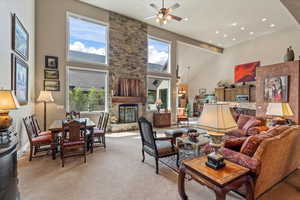 Living area featuring recessed lighting, a fireplace, a towering ceiling, and ceiling fan