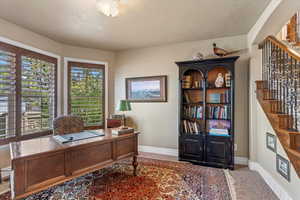Office space with baseboards and a textured ceiling