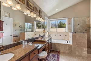 Bathroom with double vanity, vaulted ceiling, a walk in shower, a sink, and a bath