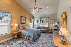 Bedroom featuring a ceiling fan, baseboards, and high vaulted ceiling