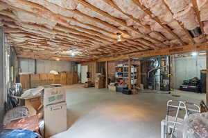 Unfinished basement with heating unit and strapped water heater