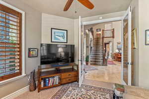 Living area with stairway, a ceiling fan, french doors, arched walkways, and baseboards