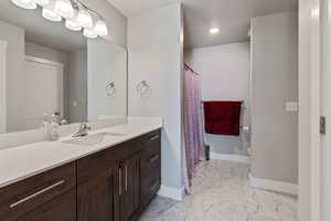 Bathroom featuring vanity, marble finish floor, baseboards, and toilet