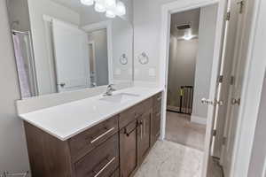 Full bath featuring baseboards, vanity, and visible vents