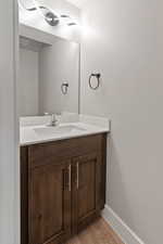 Bathroom featuring visible vents, baseboards, wood finished floors, and vanity