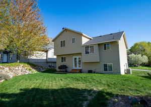 Back of house featuring a lawn, central air condition unit, entry steps, and french doors