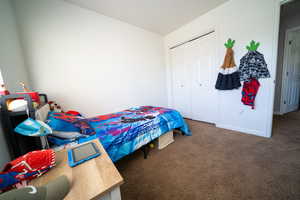 Carpeted bedroom featuring a closet and baseboards