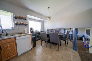 Dining area with lofted ceiling, a healthy amount of sunlight, a chandelier, and light tile patterned floors