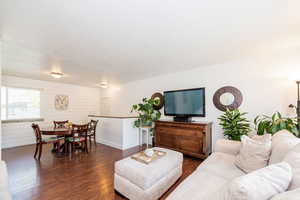 Living area featuring dark wood finished floors, baseboards, and a textured ceiling