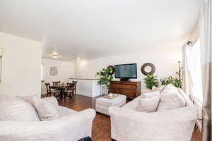 Living area with baseboards and dark wood-style floors