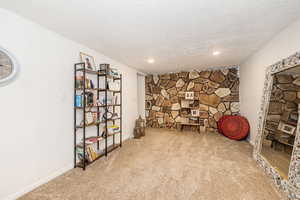 Unfurnished room featuring recessed lighting, baseboards, a textured ceiling, and carpet