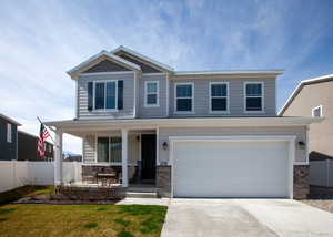 View of front of property featuring fence, concrete driveway, covered porch, and a garage.