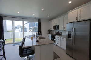 Kitchen with a wealth of natural light, a sink, recessed lighting, and appliances with stainless steel finishes