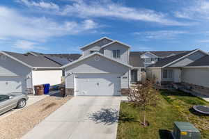 View of front of home with concrete driveway, a residential view, stone siding, entry steps, and a garage