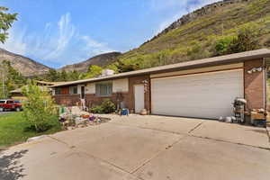 Ranch-style house featuring brick siding, concrete driveway, and a mountain view