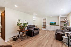 Living area featuring recessed lighting, and light wood-style laminate floors