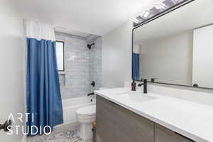 Bathroom with vanity, toilet, tile patterned flooring, and shower / tub combo with curtain
