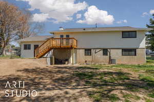 Back of house with central AC unit, a chimney, a deck, fence, and stairs