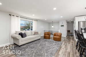 Living room with baseboards, wood finished floors, and recessed lighting