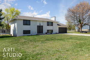 Raised ranch with a trampoline, driveway, brick siding, a front yard, and a garage