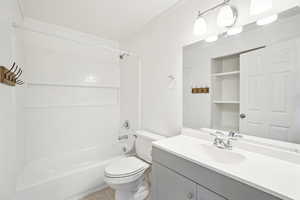 Full bathroom featuring toilet, ornamental molding, vanity, and shower / tub combination