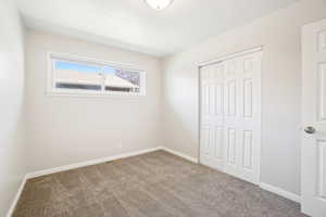 Unfurnished bedroom featuring baseboards, carpet floors, and a closet