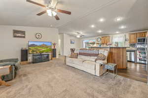 Living area featuring recessed lighting, vaulted ceiling, a ceiling fan, and carpet