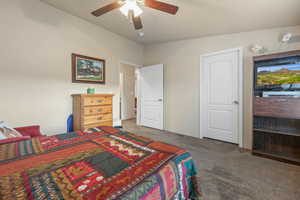 Carpeted bedroom featuring ceiling fan